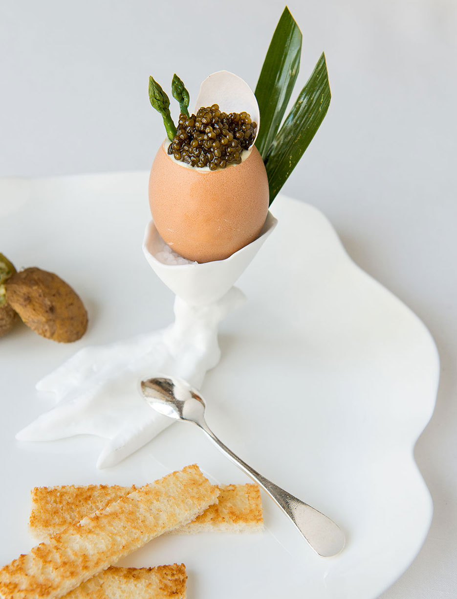 Μια χαβιάρι κορυφή του αυγού έρχεται με βουτυρωμένο τοστ και ένα ποτήρι Αρμανιάκ.