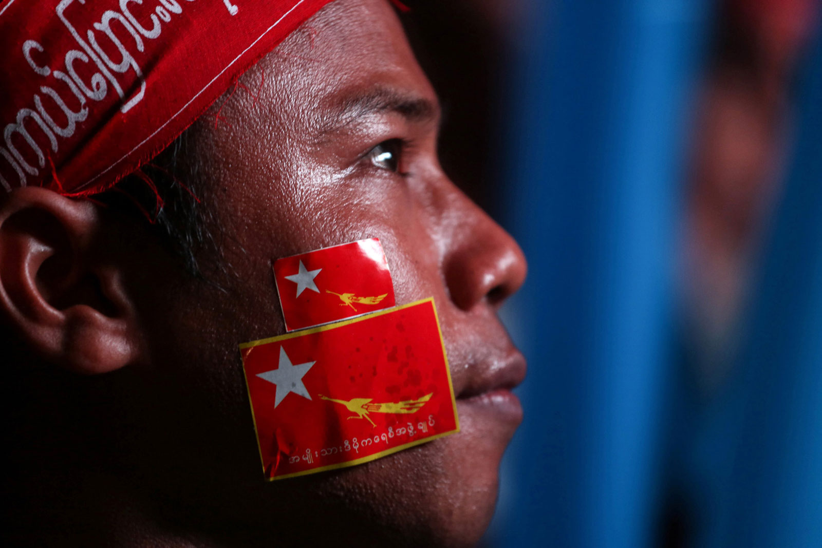 A National League for Democracy party supporter looks on during celebrations of election results outside the party headquarters in Yangon, Myanmar