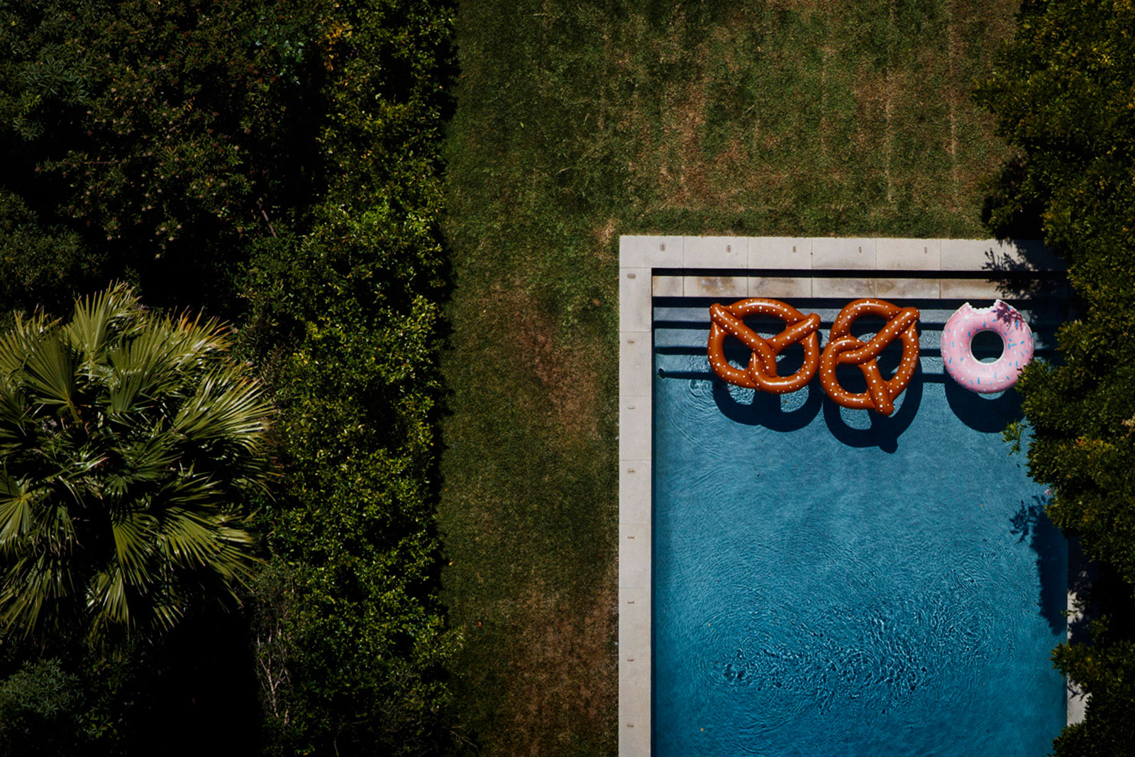 Inflatable pretzels and a doughnut float in a backyard pool at a home off Summit Drive in Los Angeles