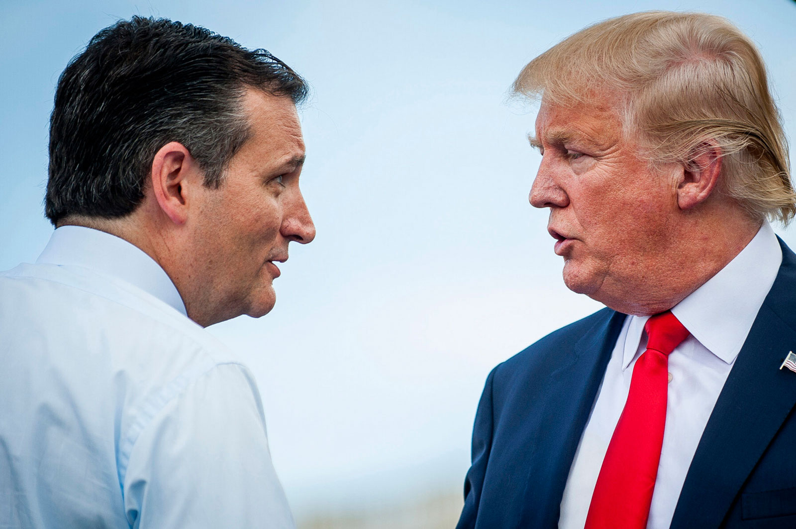 Donald Trump talks with a fellow Republican presidential candidate, Texas Senator Ted Cruz, during a rally against President Obama's nuclear deal with Iran
