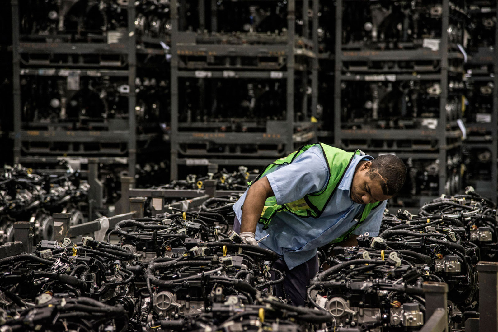An employee performs a quality-control inspection on the assembly line at the Ford Motor engine manufacturing facility in Camacari, Brazil, on Monday, July 27, 2015.