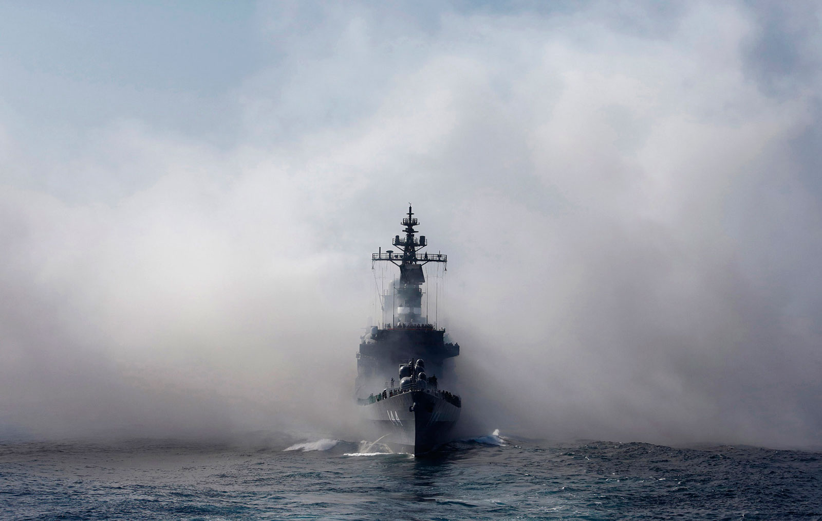 Japan Maritime Self-Defense Force destroyer ship Kurama sails as it exits the smoke of anti-IR missile flares during a review at Sagami Bay, off Yokosuka, Kanagawa Prefecture, Japan