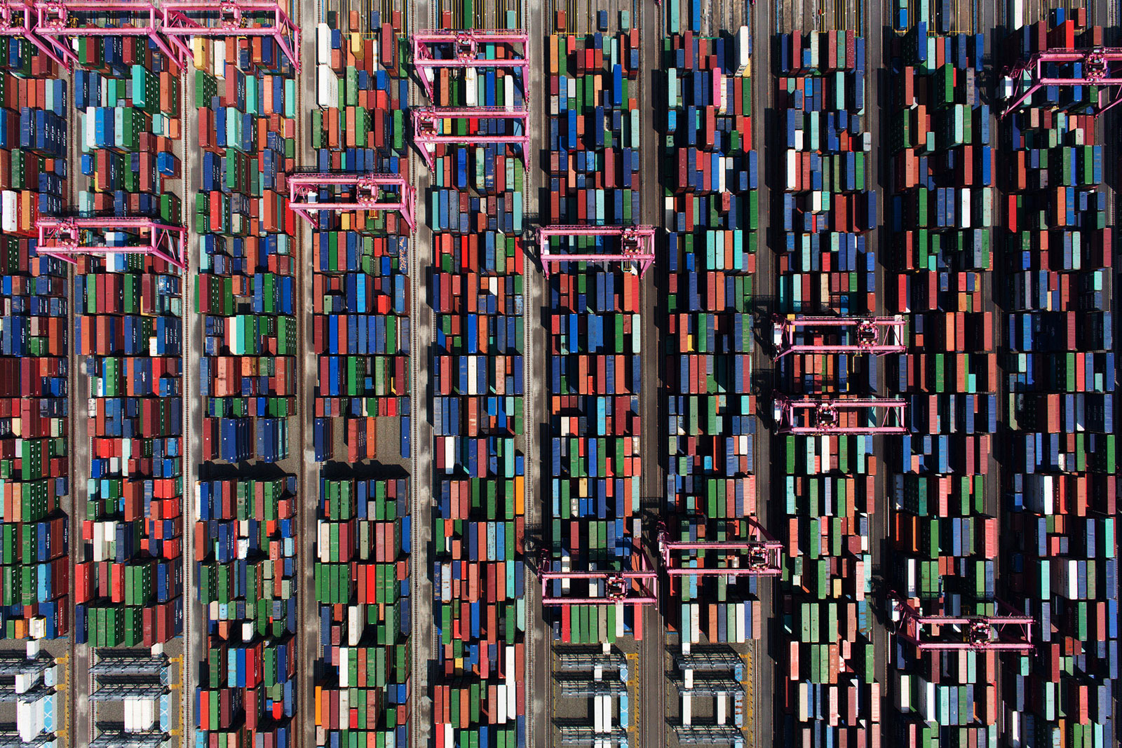 Shipping containers sit stacked among gantry cranes at the BNCT container terminal at Busan New Port in Busan, South Korea