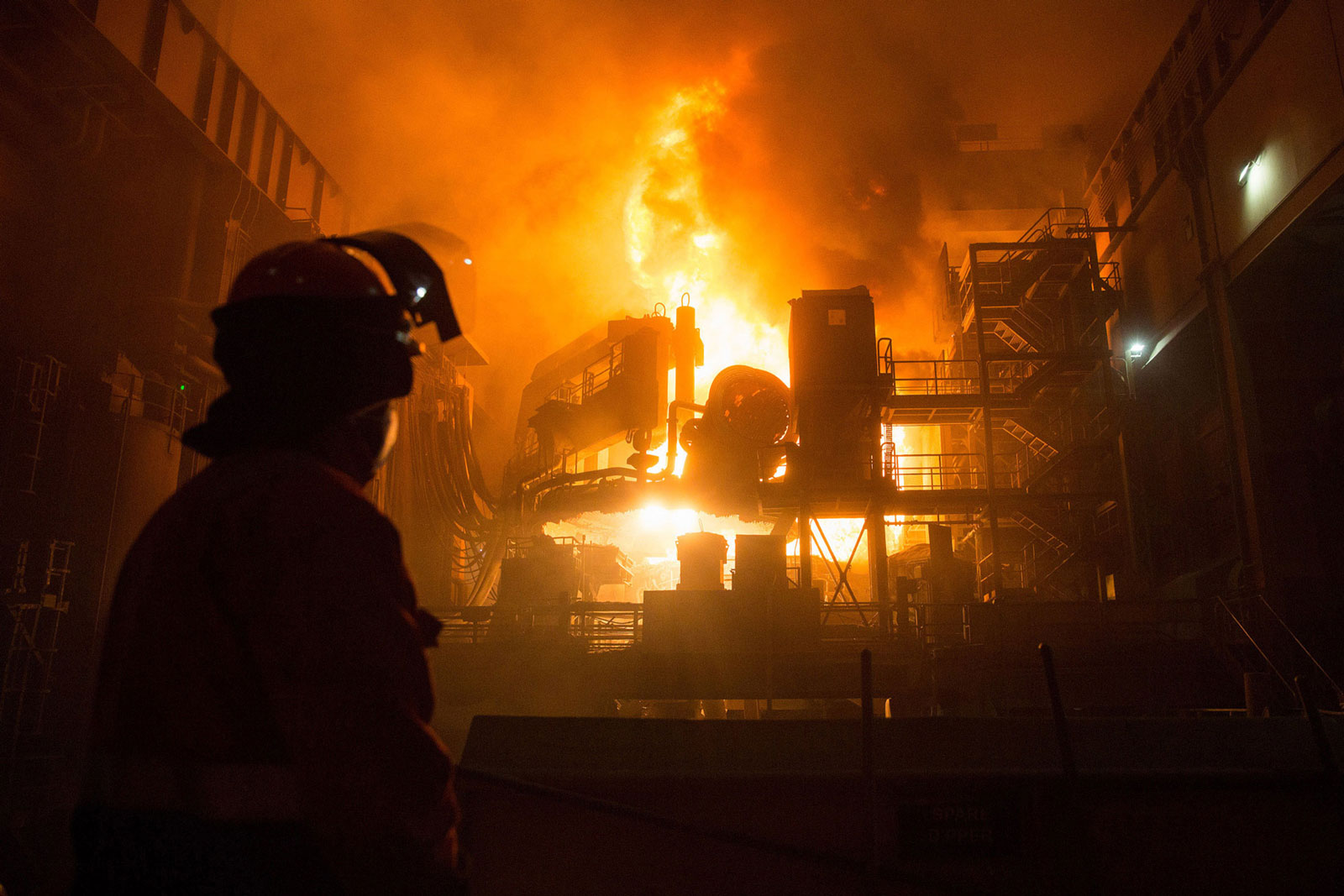 An employee looks on as a ladle is emptied in a steel mill plant at the Celsa Steel UK steel mill in Cardiff, U.K.
