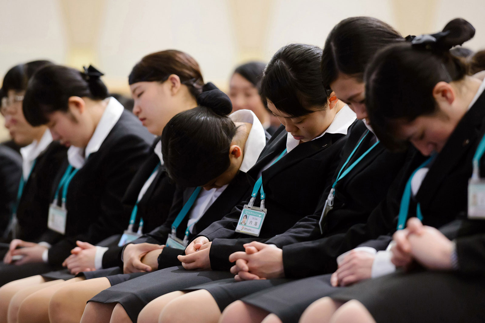 New Employees of Seven & I Holdings rest during an intermission of an initiation ceremony in Tokyo on Thursday, March 19, 2015.
