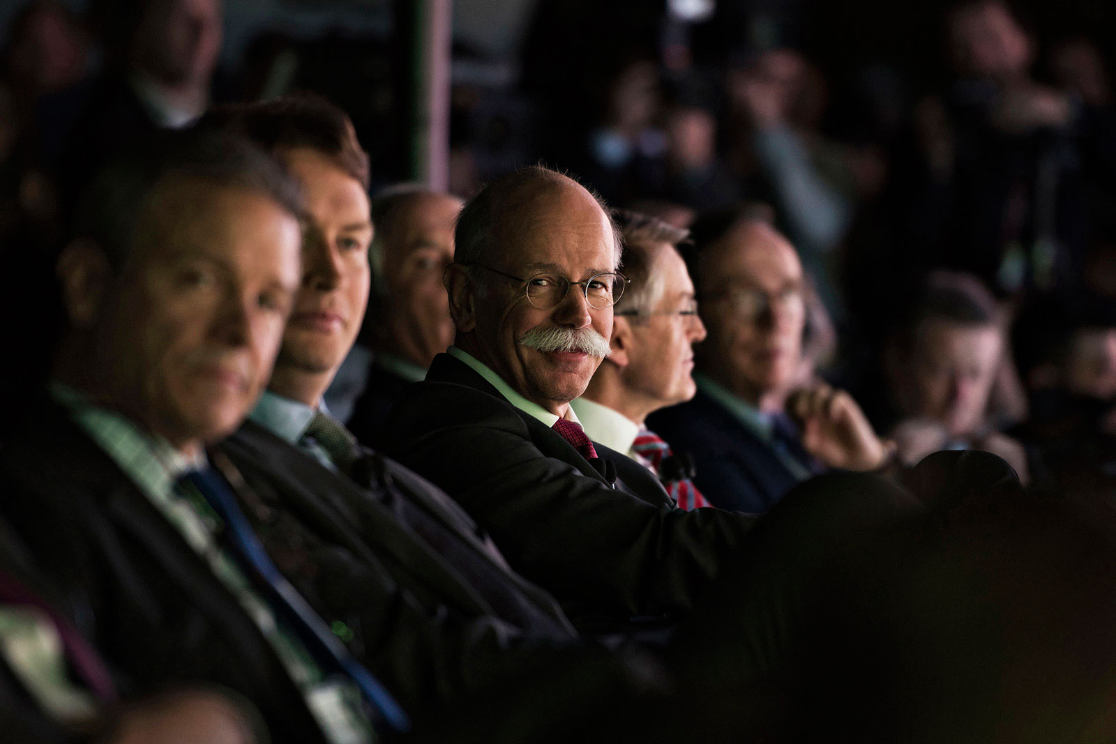 Dieter Zetsche, chief executive officer of Daimler, reacts while sitting in the audience during a Mercedes-Benz event ahead of the 2015 North American International Auto Show in Detroit