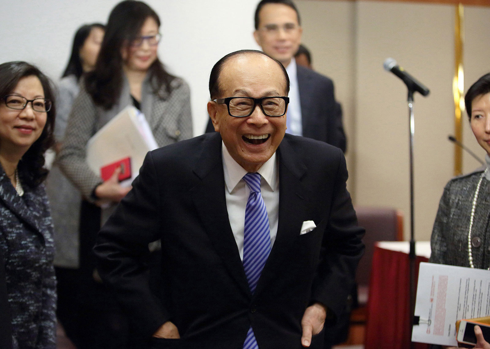 Billionaire Li Ka-shing, chairman of Cheung Kong Holdings and Hutchison Whampoa, reacts while speaking to the media as he leaves a news conference in Hong Kong