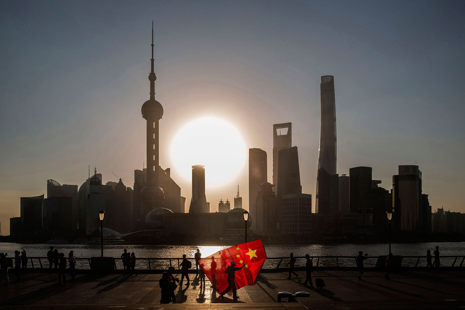 A man carrying a Chinese national flag kite walks along the Bund in Shanghai