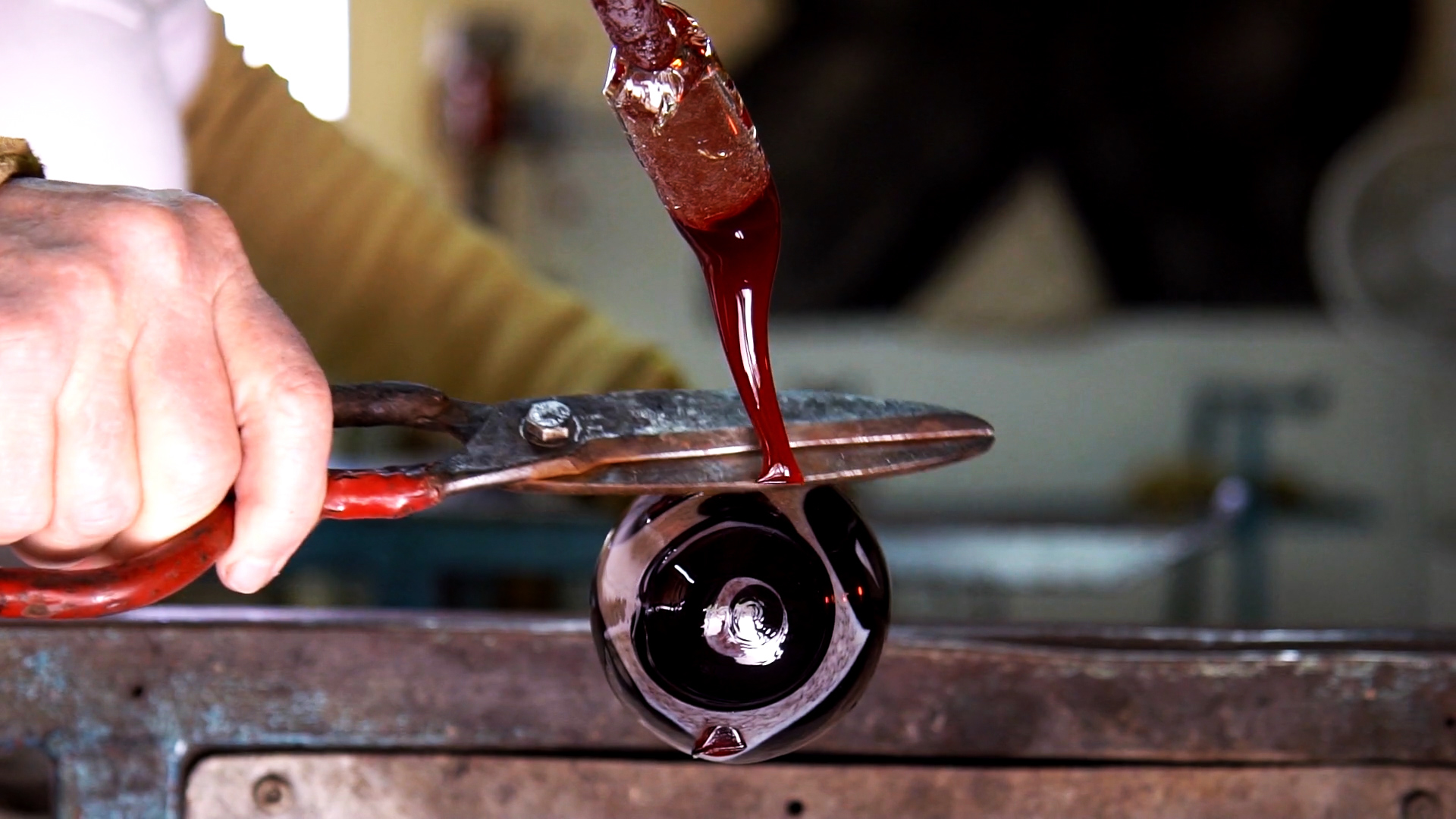 After drizzling on a design, Aronzon snips the glass with scissors. She'll then re-heat it all, literally melting the color into what will soon become a vase.