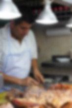 The cook at Los Cocuyos chops an assortment of meats for an order of tacos.