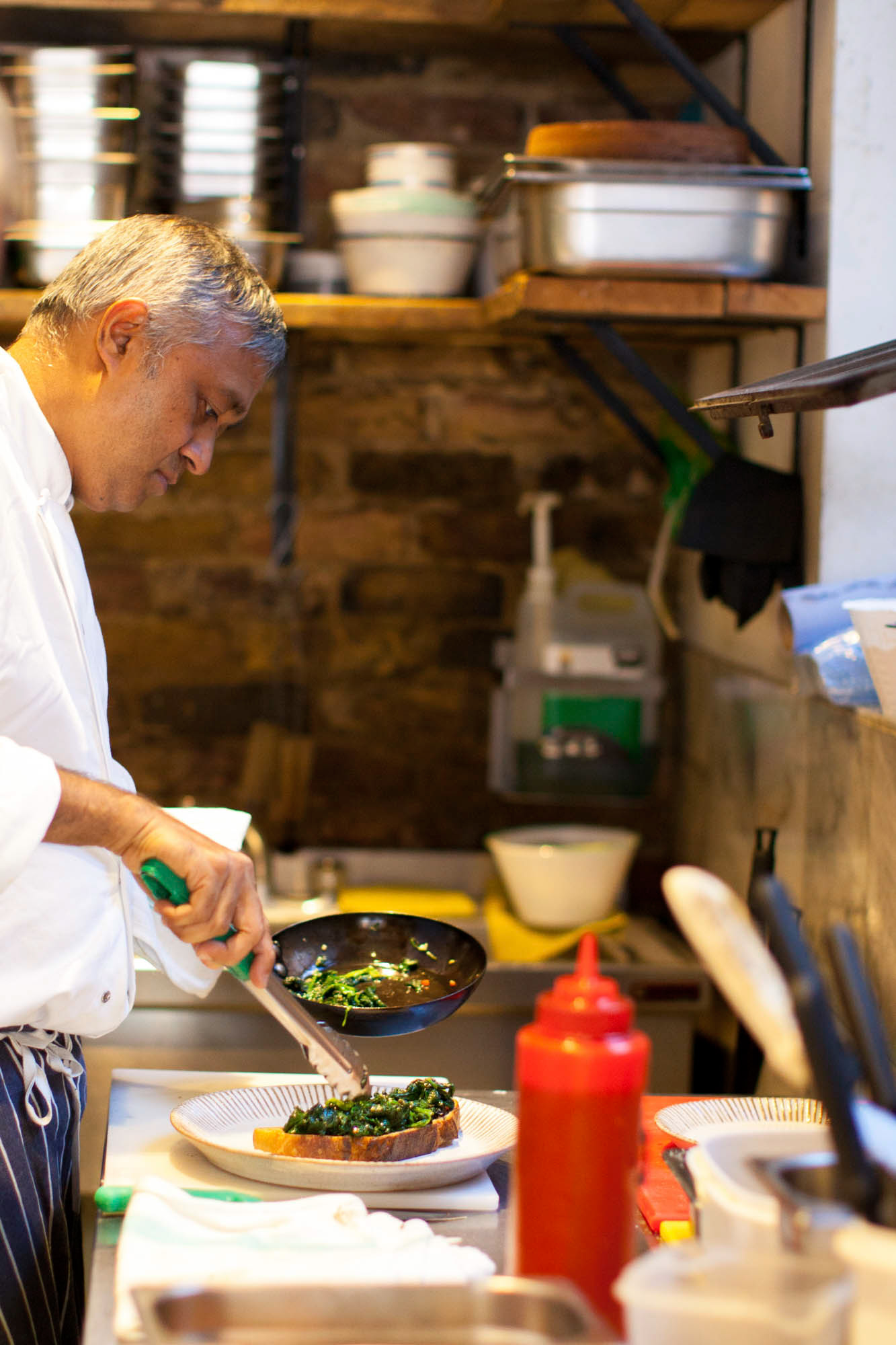 Chef Paolo de Martino plates up a serving of egg with spinach.