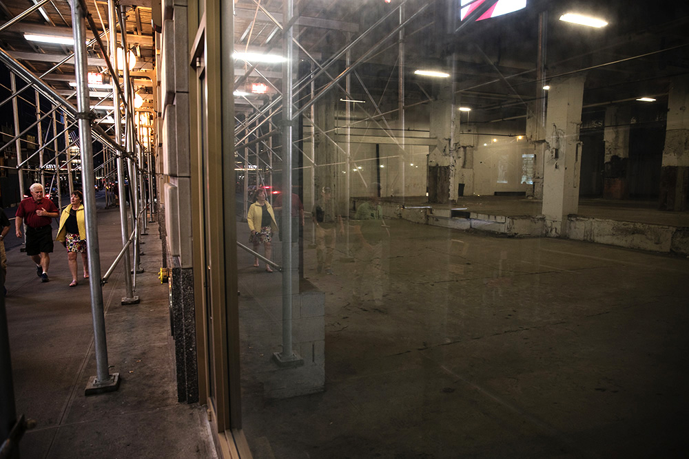 Pedestrians walk by an empty storefront of 229 W. 43rd St.