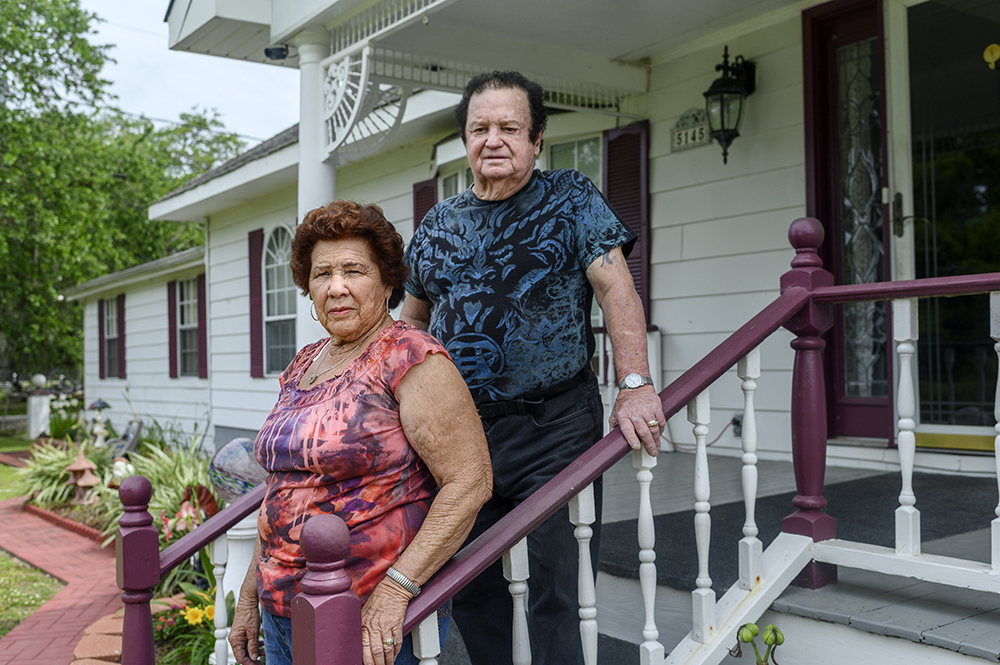 Westley and Melba Frickey standing on the stairs outside their home