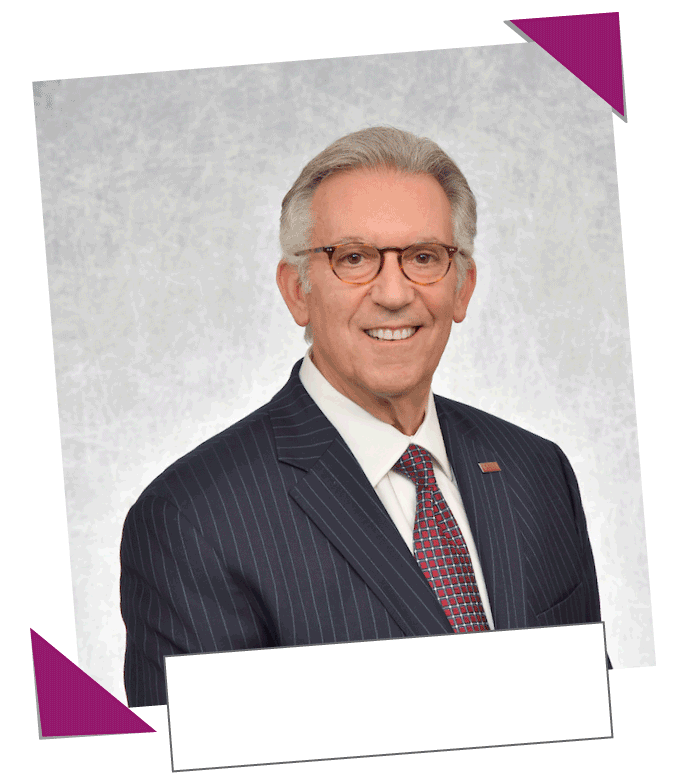 A picture of the president of rider university Gregory Dell’Omo, looking at the camera. He’s wearing a suit and a tie, and tortoise shell colored glasses. His photo looks like it was scrap-booked to the webpage.